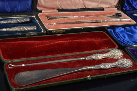 Six cased silver handled button hook and shoehorn sets