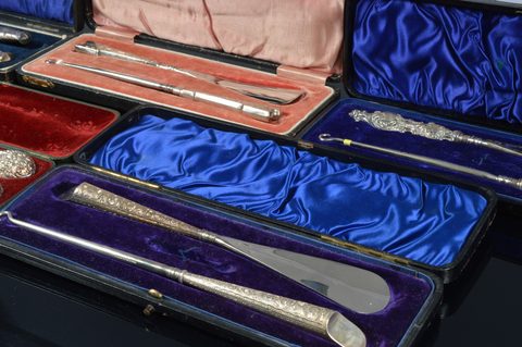 Six cased silver handled button hook and shoehorn sets
