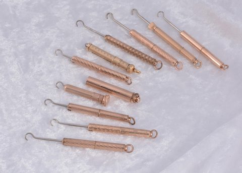 Ten gilt metal protracting and pull out sleeve button hooks