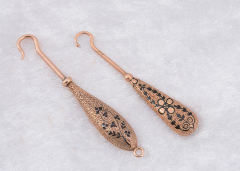 Two continental yellow metal and enamel fixed button hooks