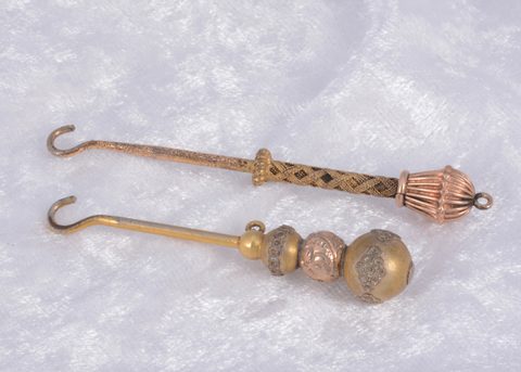 Two gold plated button hooks